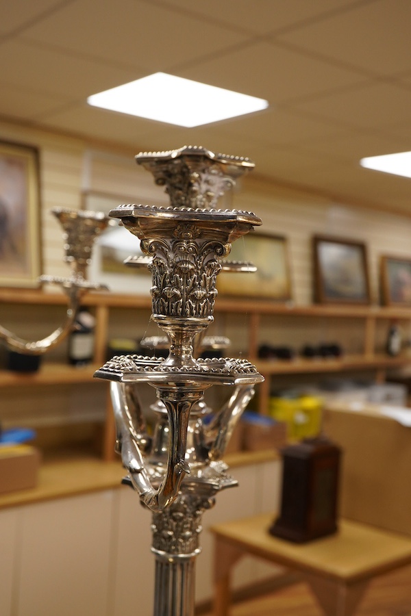 A garniture of 19th century silver plated Corinthian column candelabra, comprising a pair of two branch, three light candelabra and matching four branch, five light candelabrum, with detachable acanthus leaf capped scrol